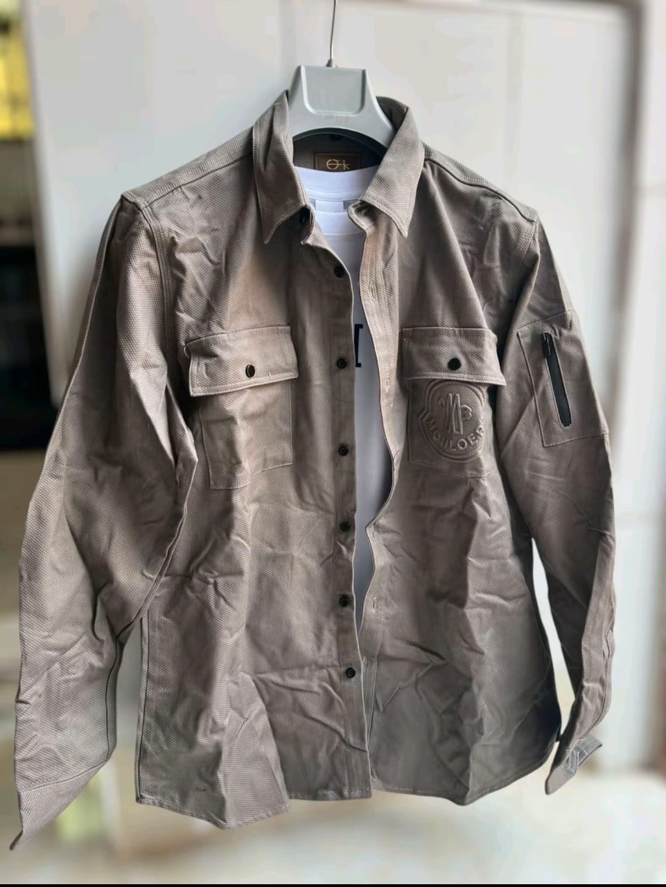 Black tactical overshirt on hanger