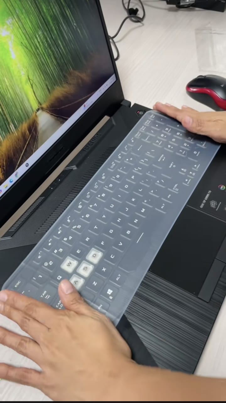 Hands placing silicone keyboard protector on laptop